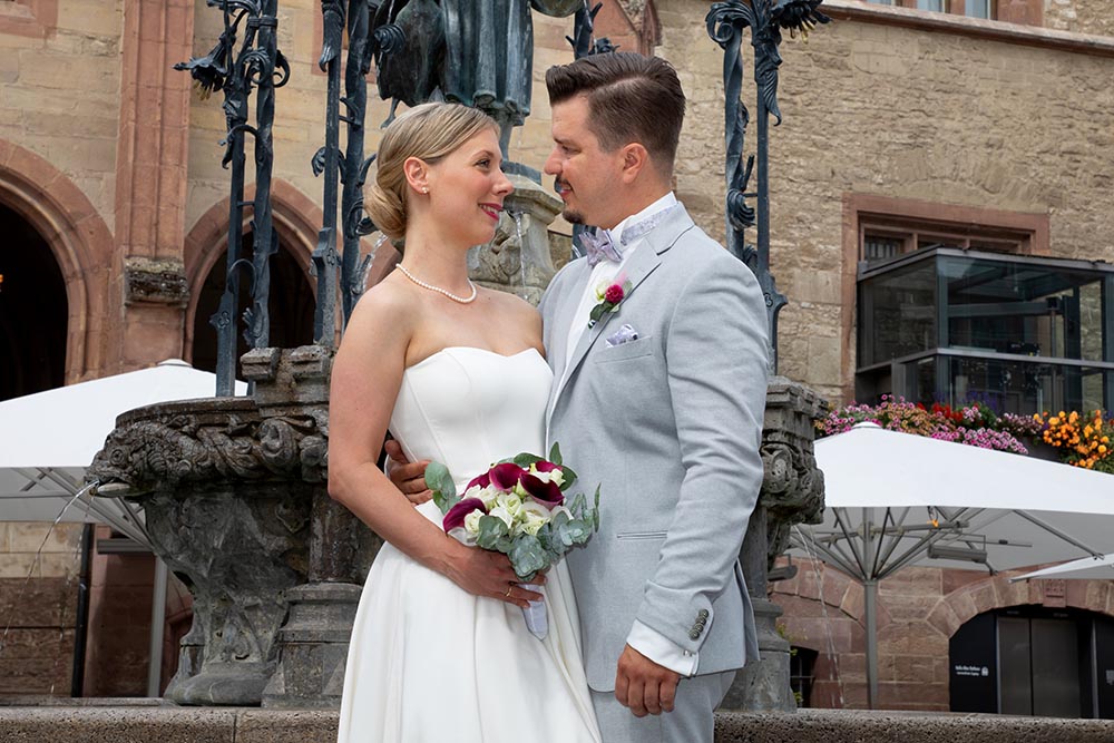 Das frischvermählte Paar posiert vor dem Alten Rathaus in Göttingen für die Fotografin Natalia Neff