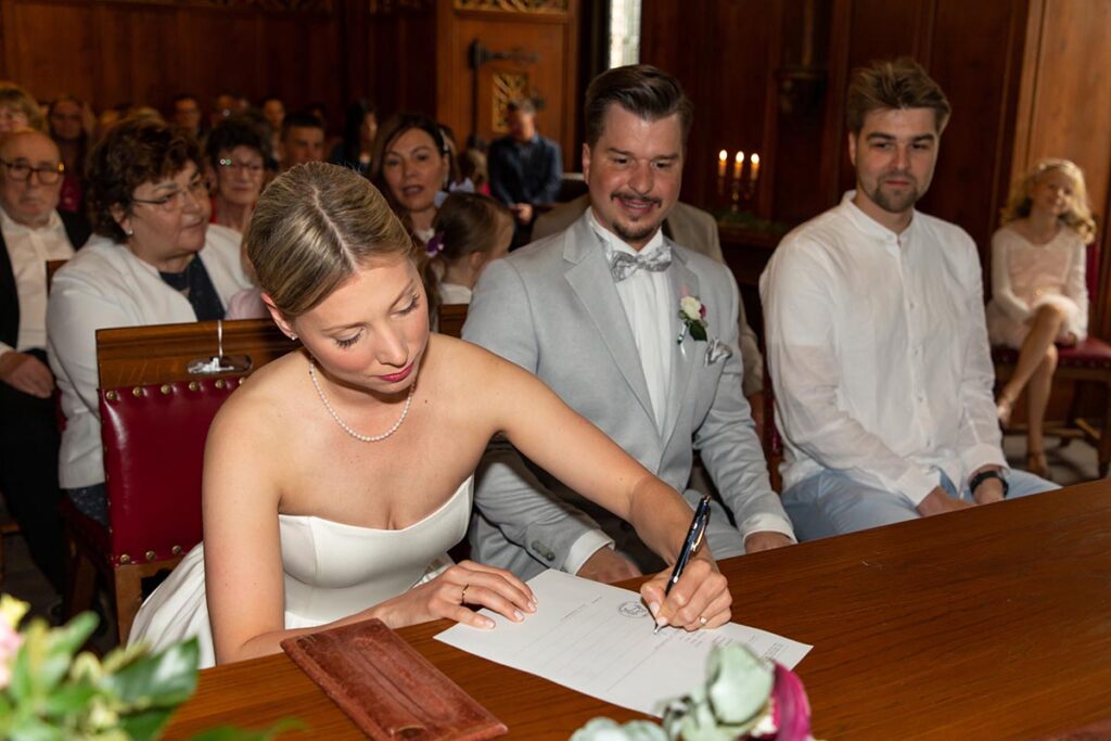 Das frischvermählte Paar unterzeichnet die Unterlagen im Standesamt